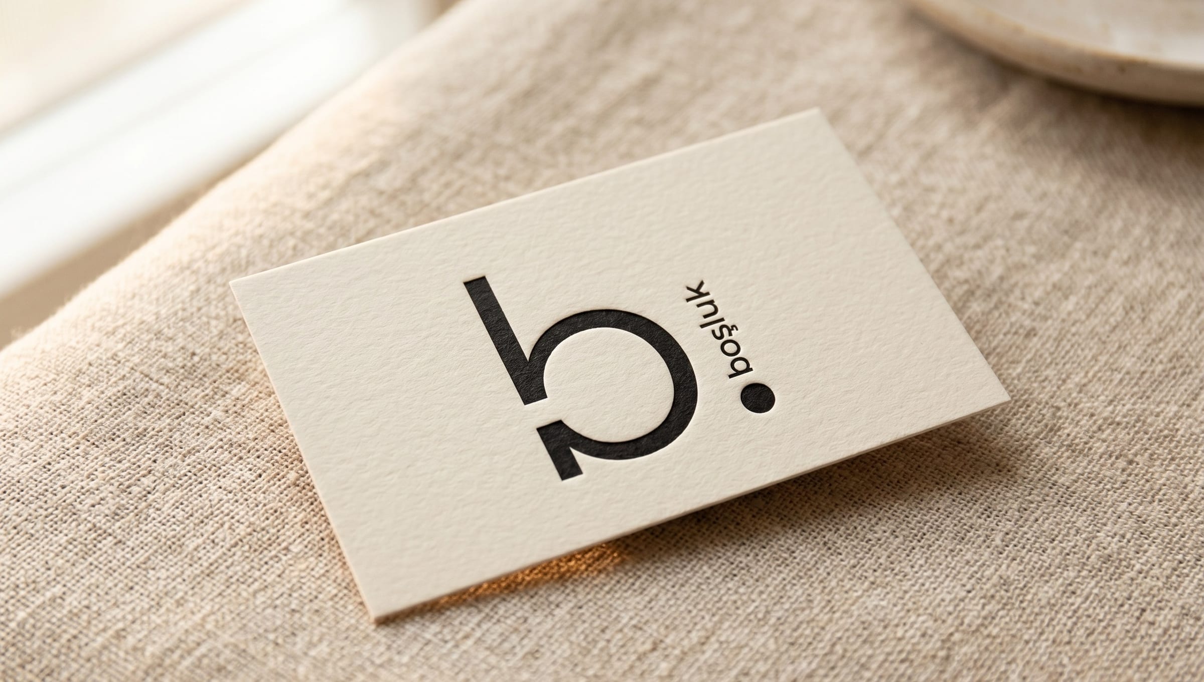 Boşluk-Visitenkarte auf Leinenstoff, Logo und minimale Typografie.