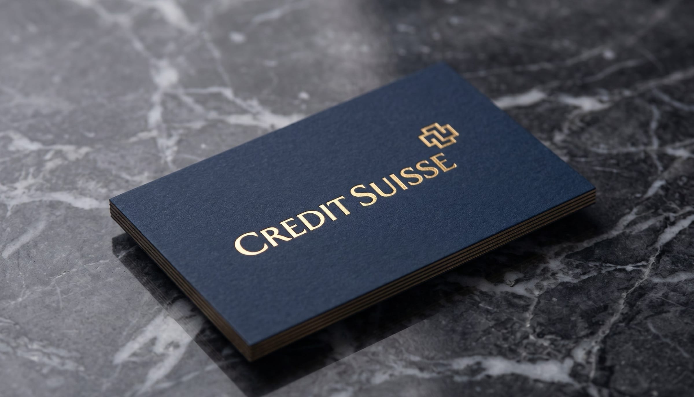Credit-Suisse-Visitenkarte auf dunklem Marmor, mit dem Wermelinger-Kreuz.