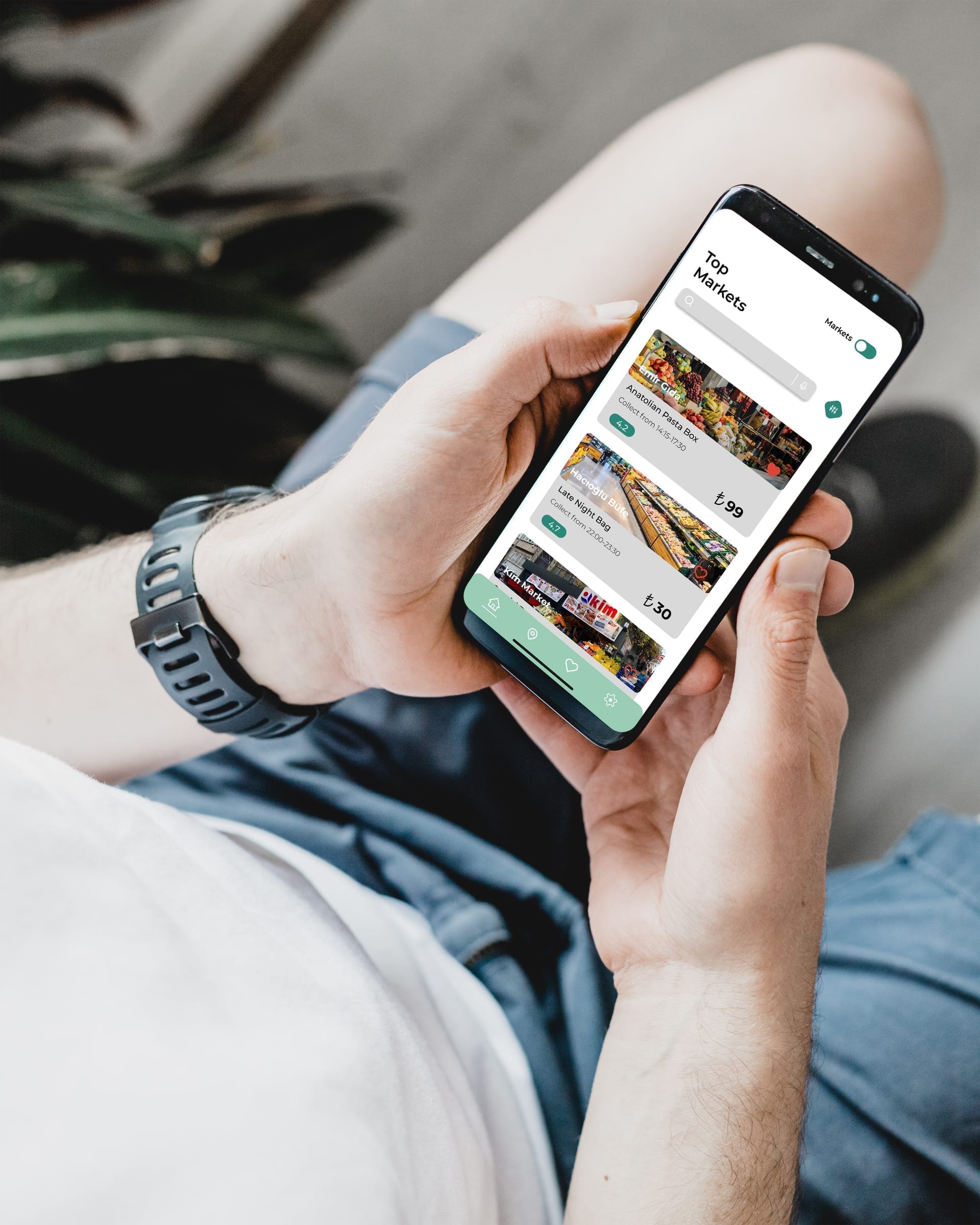 Person hält ein Android-Smartphone mit GreenPlates+ Marktlistings in einer entspannten Außenumgebung.