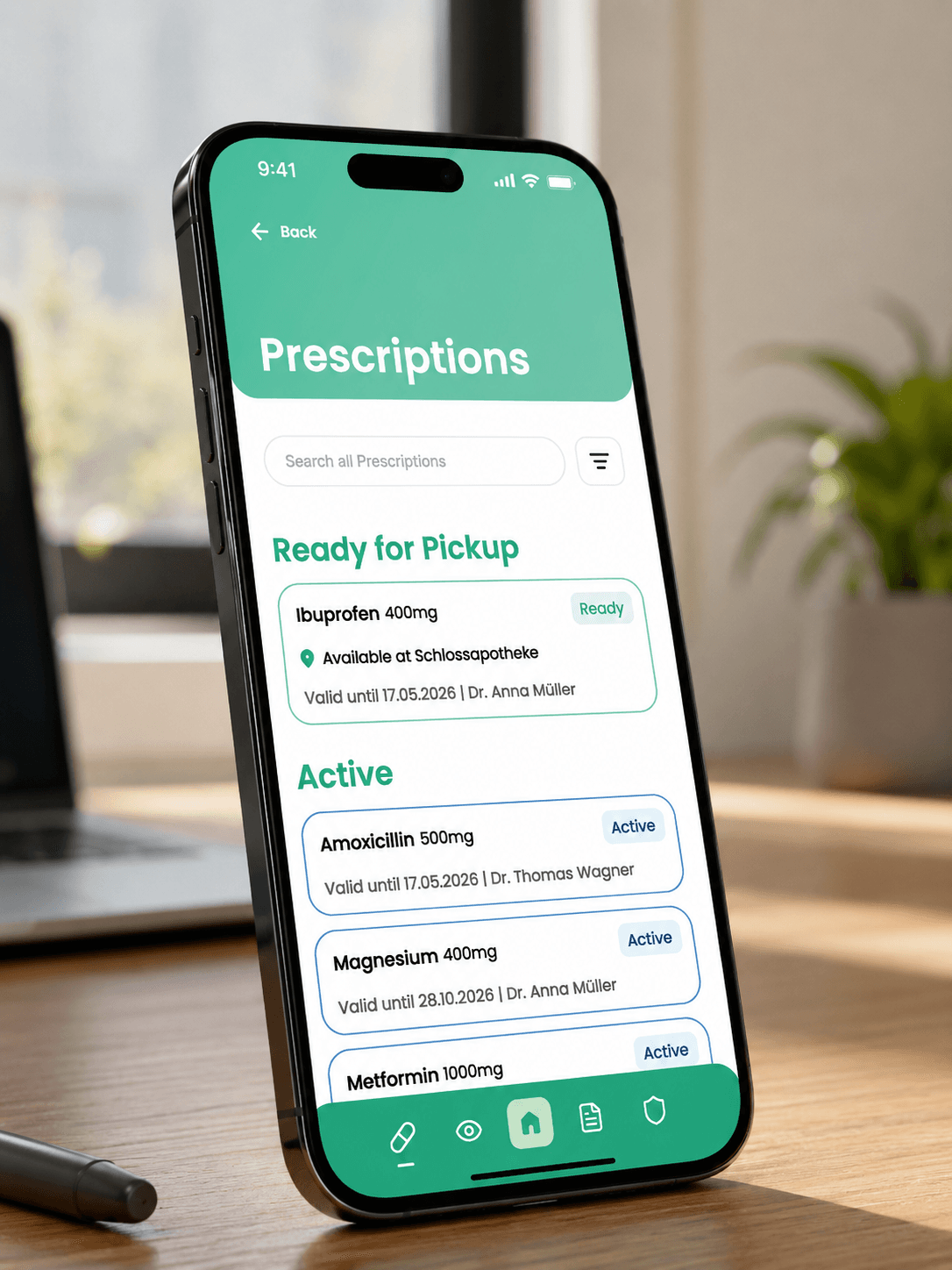 MedPass prescriptions mockup on a phone standing on a desk, showing ready-for-pickup and active prescriptions.