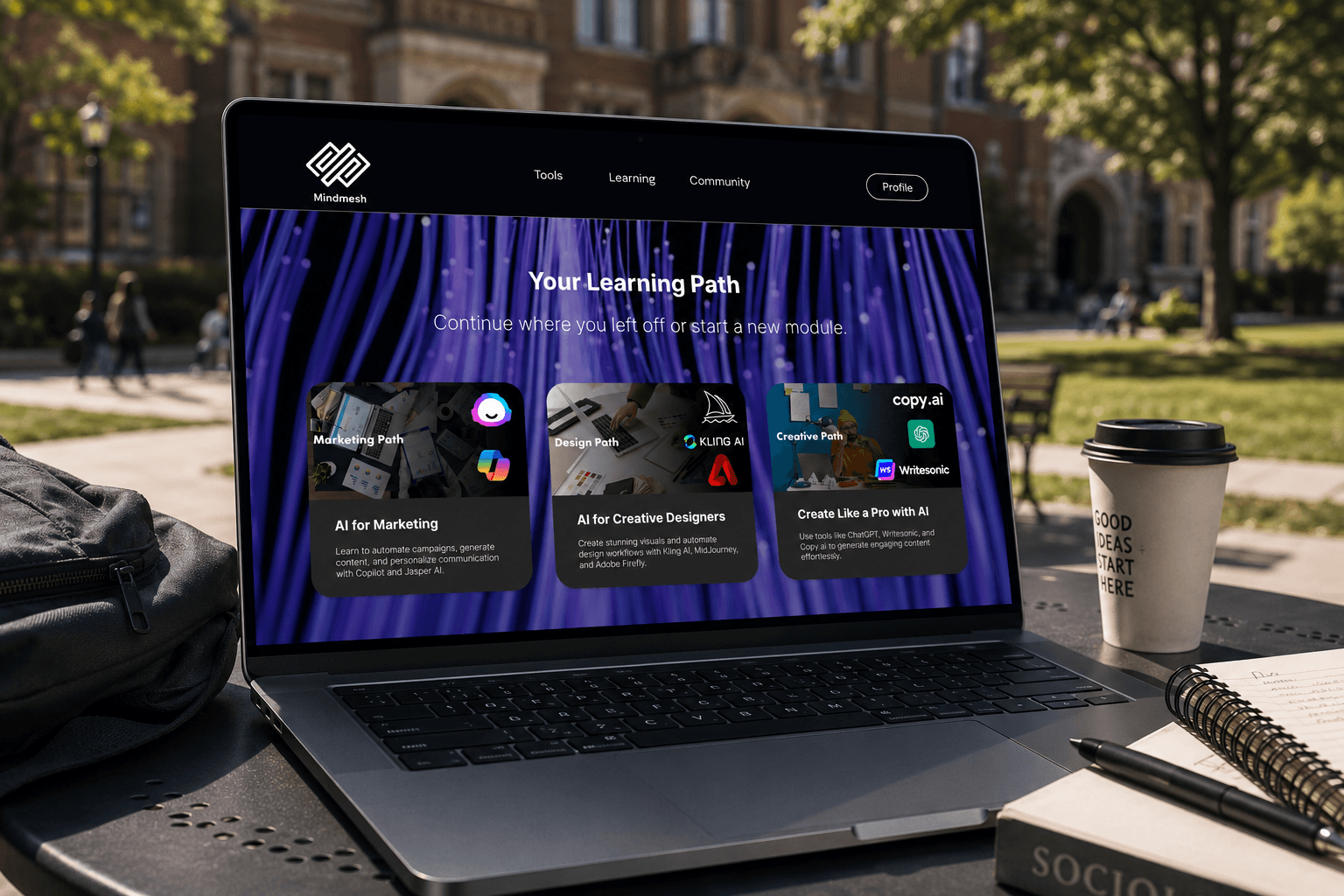 MindMesh Lernpfad-Bildschirm auf einem MacBook Pro auf einem Campus, der Ihr Lernpfad mit drei Pfadkarten zeigt: Marketing Path, Design Path und Creative Path mit Kling AI und copy.ai Logos.